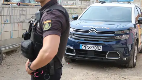 Imagen de un agente y un coche patrulla de la Policía Nacional Imagen de un agente y un coche patrulla de la Policía Nacional