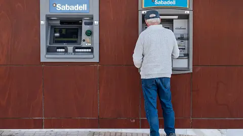 Imagen de archivo. Un cliente retirando dinero de un cajero automático del banco Sabadell de servicios financieros multinacional español. Imagen de archivo. Un cliente retirando dinero de un cajero automático del banco Sabadell de servicios financieros multinacional español.