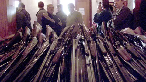 Varios hombres observan las cerca de mil armas expuestas, para una subasta, en el cuartel de la Guardia Civil del barrio de Patraix de Valencia Varios hombres observan las cerca de mil armas expuestas, para una subasta, en el cuartel de la Guardia Civil del barrio de Patraix de Valencia