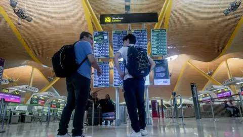 Dos personas observan el panel de salidas en la T4, en el aeropuerto Adolfo Suárez Madrid-Barajas. Dos personas observan el panel de salidas en la T4, en el aeropuerto Adolfo Suárez Madrid-Barajas.