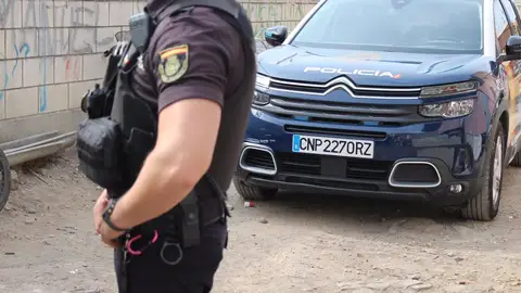 Imagen de un agente y un coche patrulla de la Policía Nacional. - POLICÍA NACIONAL Imagen de un agente y un coche patrulla de la Policía Nacional. - POLICÍA NACIONAL