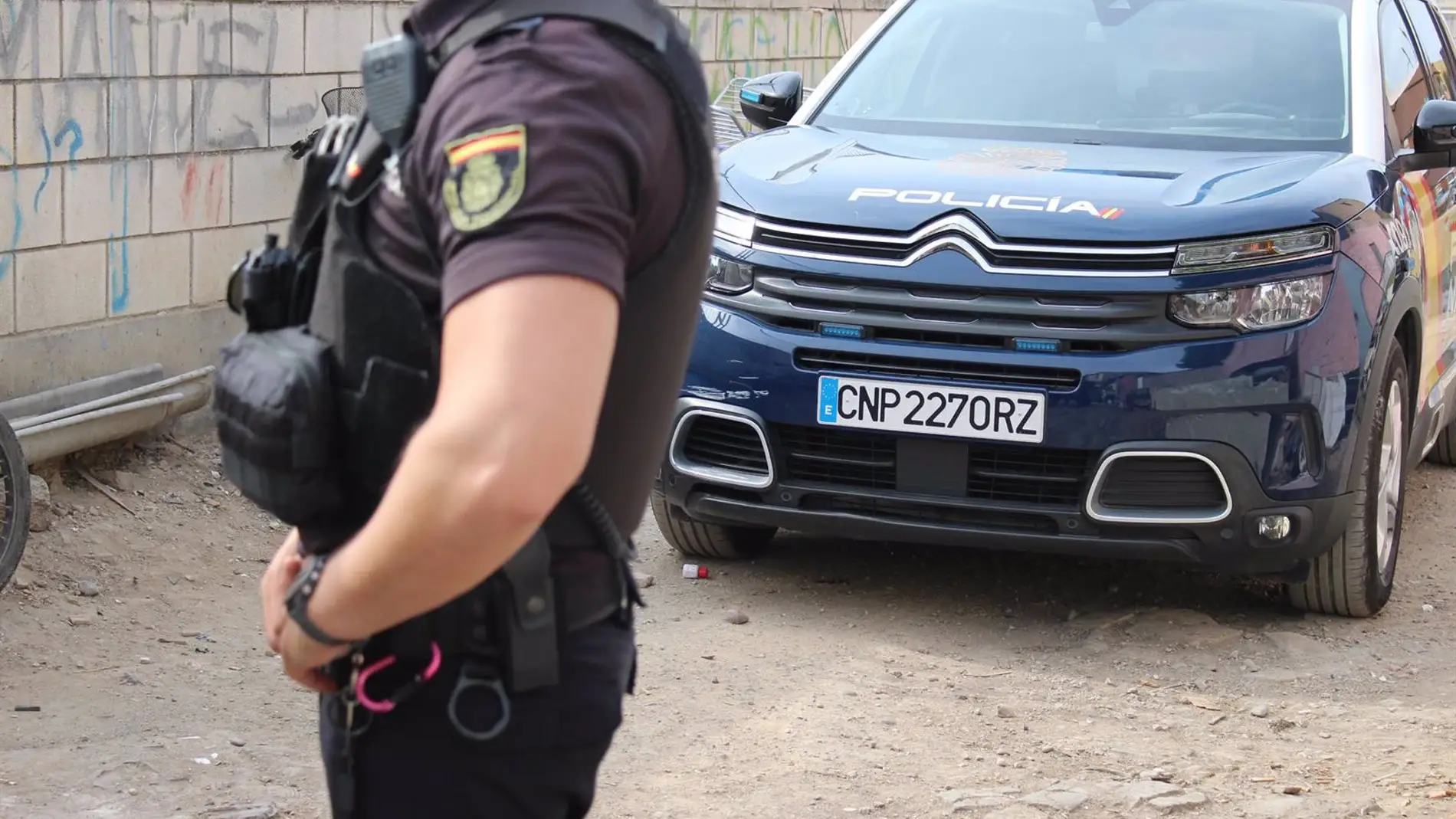 Imagen de un agente y un coche patrulla de la Policía Nacional. - POLICÍA NACIONAL Imagen de un agente y un coche patrulla de la Policía Nacional. - POLICÍA NACIONAL