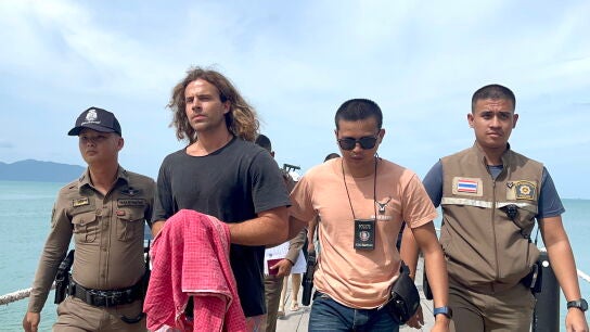 Fotograf&iacute;a de archivo de Daniel Sancho tras su detenci&oacute;n en Tailandia, escoltado por agentes de seguridad tailandeses cruzando un embarcadero.