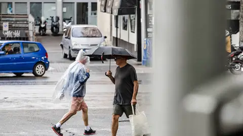 Imagen de archivo Dos personas caminan bajo la lluvia en Madrid. Imagen de archivo Dos personas caminan bajo la lluvia en Madrid.