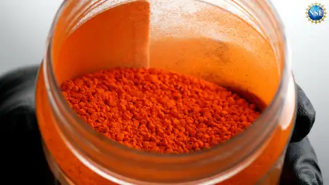 Primer plano de una mano enguantada sacando colorante FD & C Yellow 5 sin disolver de un tarro de cristal. Primer plano de una mano enguantada sacando colorante FD & C Yellow 5 sin disolver de un tarro de cristal.