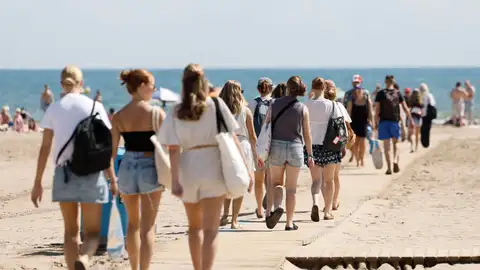 Personas caminan en la playa de la Malvarrosa este viernes en Valencia Personas caminan en la playa de la Malvarrosa este viernes en Valencia