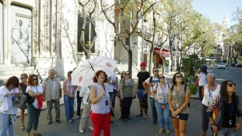 Una guía turística ofrece sus explicaciones junto a La Lonja