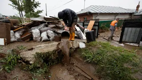Una persona en Rumanía achicando agua tras las graves inundaciones Una persona en Rumanía achicando agua tras las graves inundaciones