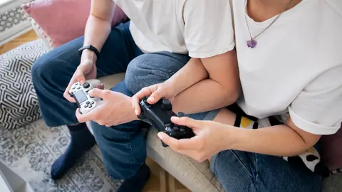 Pareja jugando a videojuegos en el sofá Pareja jugando a videojuegos en el sofá