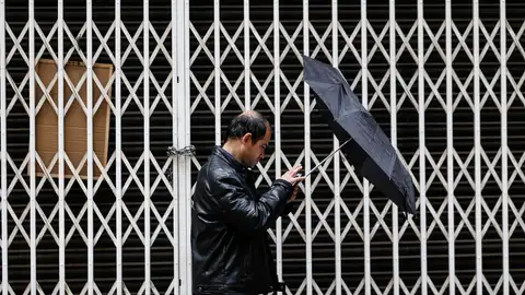 Un hombre camina bajo la lluvia en Valencia Un hombre camina bajo la lluvia en Valencia