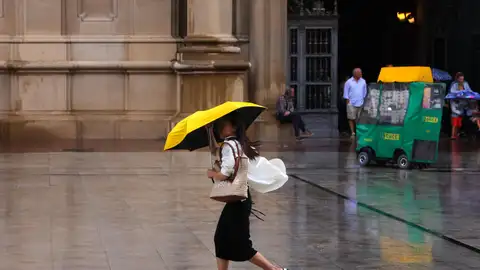 Una mujer se protege de la lluvia con un paraguas en el centro de Zaragoza, en una fotografía de archivo. Una mujer se protege de la lluvia con un paraguas en el centro de Zaragoza, en una fotografía de archivo.
