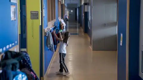 Archivo - Una niña cuelga su mochila en un colegio (archivo). Archivo - Una niña cuelga su mochila en un colegio (archivo).