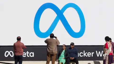 Fotografía de archivo de personas tomando fotos a un cartel con el logotipo de Meta. Fotografía de archivo de personas tomando fotos a un cartel con el logotipo de Meta.