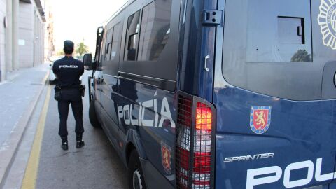 Agente junto a furg&oacute;n policial