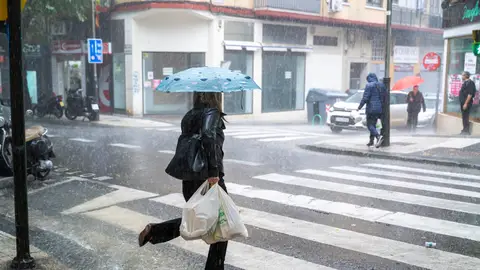Personas caminan bajo la lluvia en Zaragoza Personas caminan bajo la lluvia en Zaragoza