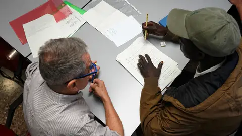 Un voluntario de Cáritas atiende a una persona migrante en curso formativo. Un voluntario de Cáritas atiende a una persona migrante en curso formativo.