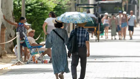 Pareja de turistas extranjeros paseando por Sevilla en verano Pareja de turistas extranjeros paseando por Sevilla en verano