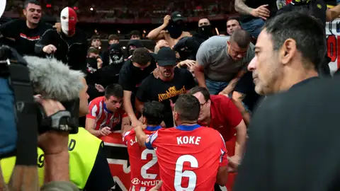 Varios jugadores del Atlético de Madrid intentando calmar a los radicales durante el derbi Varios jugadores del Atlético de Madrid intentando calmar a los radicales durante el derbi