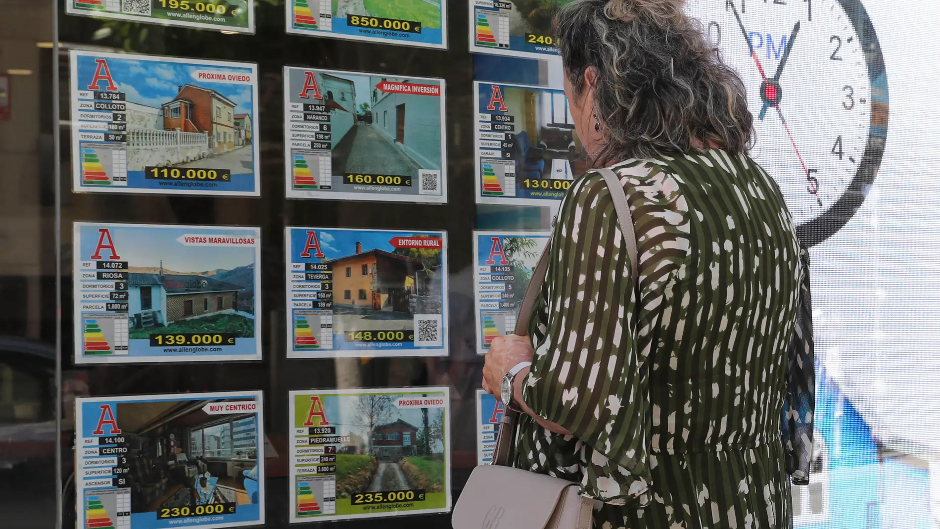 Archivo. Una mujer delante del escaparate de una agencia inmobiliaria. Archivo. Una mujer delante del escaparate de una agencia inmobiliaria.