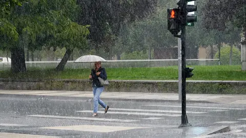 Una mujer se protege de la lluvia con un paraguas, en una fotografía de archivo. El huracán Kirk se acerca a España: fuertes vientos y lluvias en los próximos días