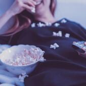 Una mujer come palomitas mientras ve una película