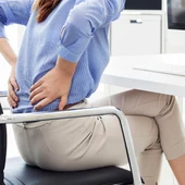 Una dona treballant i amb dolor d'esquena Una dona treballant i amb dolor d'esquena