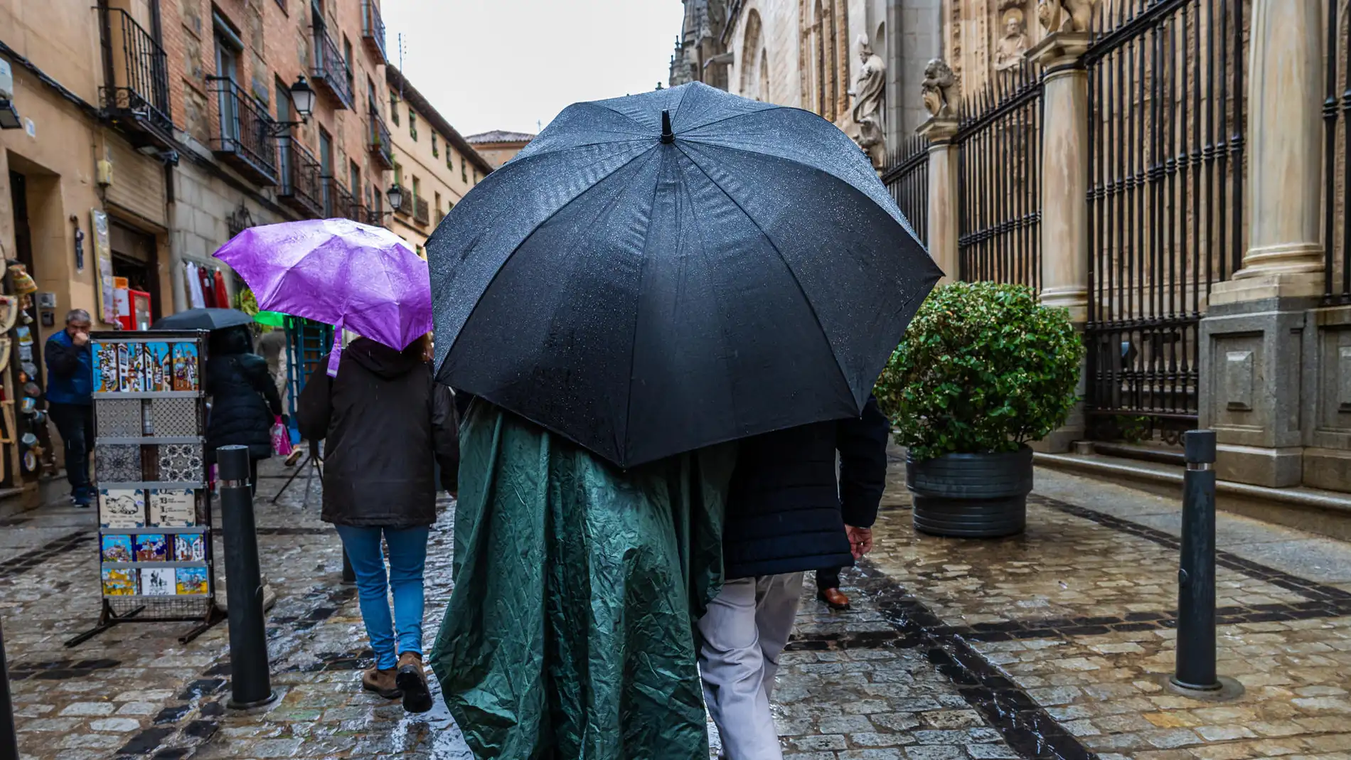 Varias personas se protegen de la lluvia en Toledo Varias personas se protegen de la lluvia en Toledo