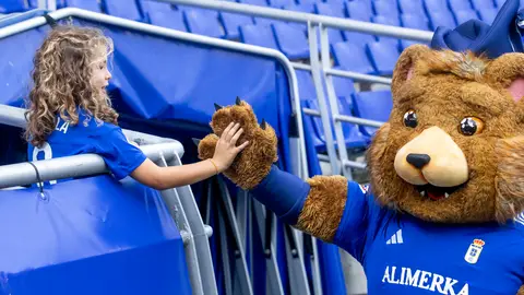 La mascota del Oviedo saluda a una niña en el Tartiere La mascota del Oviedo saluda a una niña en el Tartiere