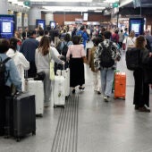 Varias personas esperan la salida de un tren en la Estación de Atocha