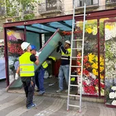 Uns operaris desmunten una parada de flors de la Rambla Uns operaris desmunten una parada de flors de la Rambla