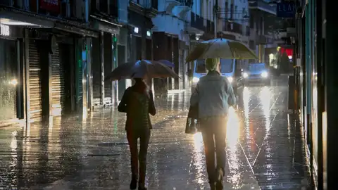 Dos personas se protegen de la lluvia con un paraguas en la Comunidad Valenciana. Dos personas se protegen de la lluvia con un paraguas en la Comunidad Valenciana.