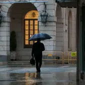 Transeúnte refugiado de la lluvia con paraguas Transeúnte refugiado de la lluvia con paraguas