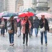 Personas se protegen de la lluvia con paraguas en Bilbao