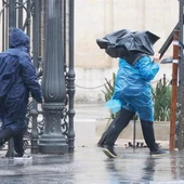 Dos personas caminan bajo la lluvia junto al Rectorado Dos personas caminan bajo la lluvia junto al Rectorado