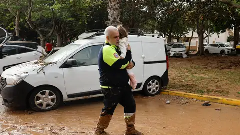 Un miembro de transporte sanitario con una niña tras las intensas lluvias de la fuerte DANA. Un miembro de transporte sanitario con una niña tras las intensas lluvias de la fuerte DANA.
