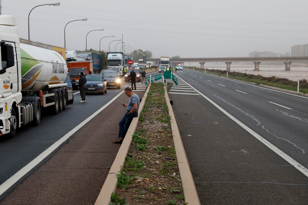 arios conductores aguardan junto a sus vehículos en la V-30 junto al nuevo cauce del Turia durante la mañana de este miércoles arios conductores aguardan junto a sus vehículos en la V-30 junto al nuevo cauce del Turia durante la mañana de este miércoles