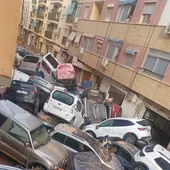 Una montaña de coches apilados en una calle de Benetússer Una montaña de coches apilados en una calle de Benetússer