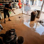 Un hombre retira el lodo acumulado en el interior de su comercio en la localidad valenciana de Catarroja, tras las intensas lluvias caídas por la fuerte dana. 