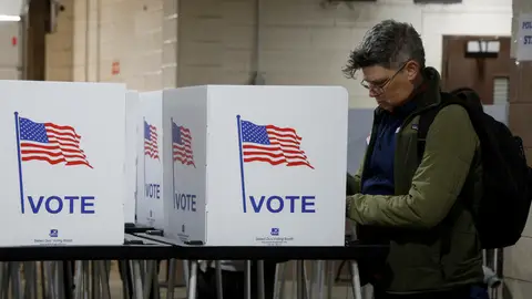 Votante estadounidense rellenando las papeletas de las elecciones Votante estadounidense rellenando las papeletas de las elecciones