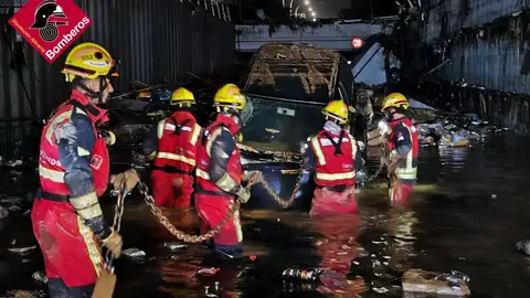 Los bomberos mueven un coche en un paso inferior Los bomberos mueven un coche en un paso inferior