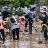 Vecino y personas de diversas comunidades autónomas trabajan como voluntarios para restablecer la normalidad en Alfafar (Valencia).