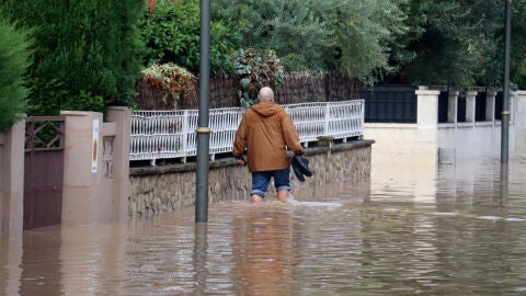 Un home camina per un carrer inundat de la urbanitzaci&oacute; La Mora de Tarragona