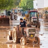 Agricultores con tractores en las zonas devastadas. 