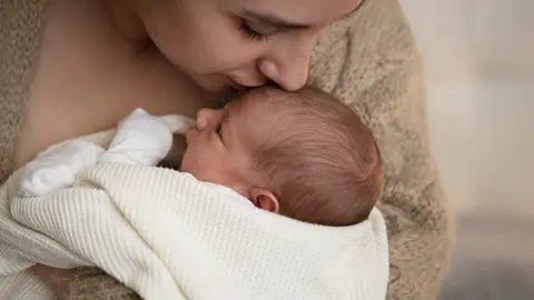 Madre sostiene a su bebé recién nacido Madre sostiene a su bebé recién nacido