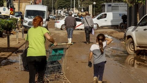 Dos personas entre escombros en Sedav&iacute;, uno de los municipios m&aacute;s afectados por la DANA.