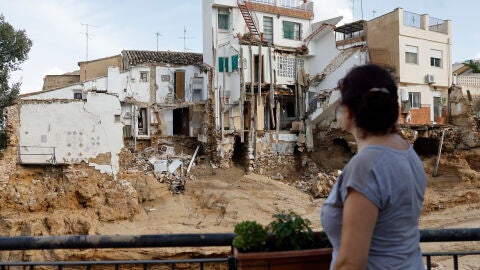 Una mujer observa varias casas da&ntilde;adas en Chiva tras la dana, el pasado jueves