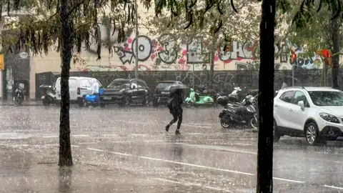 Una persona camina bajo la lluvia en Barcelona Una persona camina bajo la lluvia en Barcelona