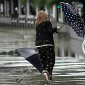 Una mujer se intenta proteger de la fuerte lluvia y el viento con un paraguas, en una imagen de archivo. Una mujer se intenta proteger de la fuerte lluvia y el viento con un paraguas, en una imagen de archivo.
