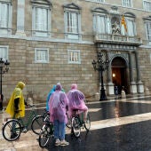 Ciclistas visten impermeables a causa de la lluvia 