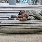 Una persona dormint en un banc, en situació d'excusió social i residencial extrema Una persona dormint en un banc, en situació d'excusió social i residencial extrema